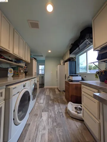 Laundry area with light wood-style floors, recessed lighting, washing machine and dryer, and cabinet space