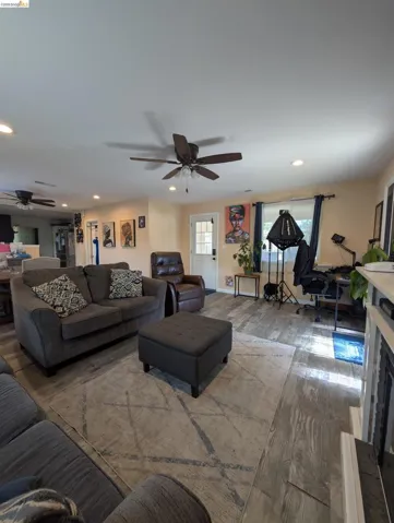 Living area with a ceiling fan, wood finished floors, and recessed lighting
