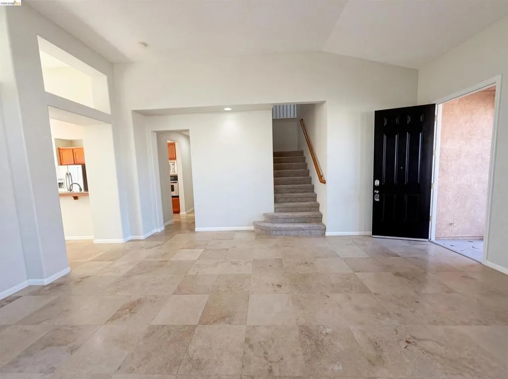 Entrance foyer with stairs and vaulted ceiling