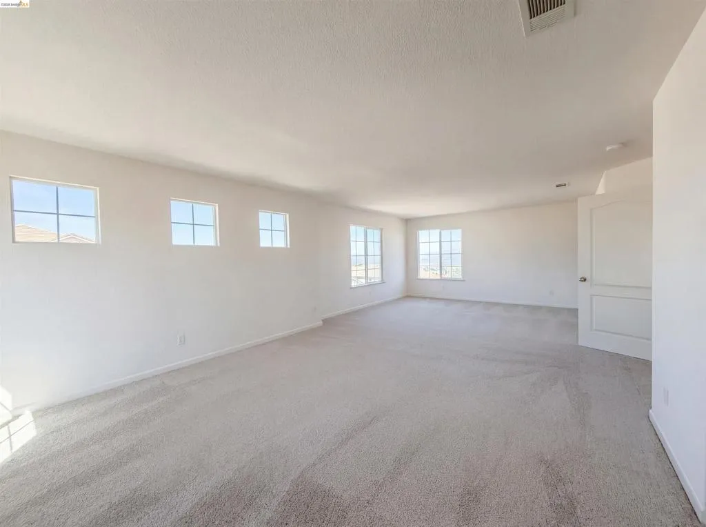 Spare room featuring carpet floors and baseboards