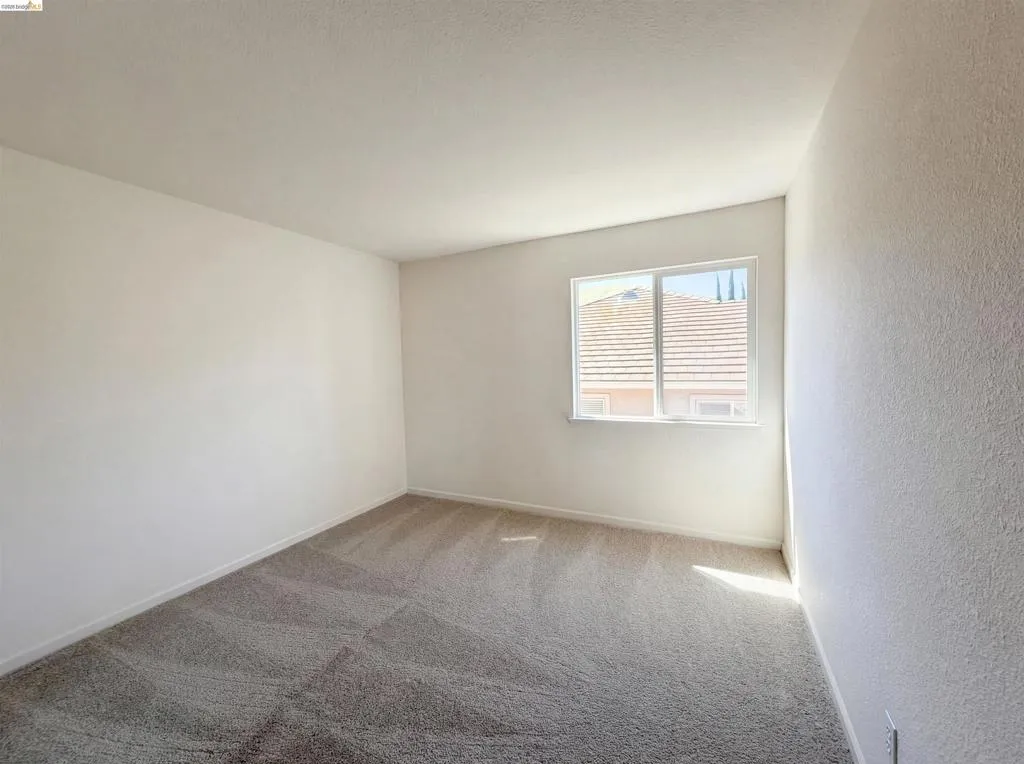Spare room featuring light colored carpet and baseboards