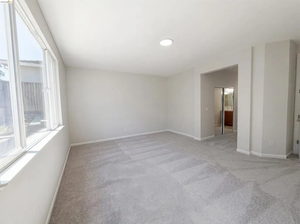 Spare room with light carpet and baseboards