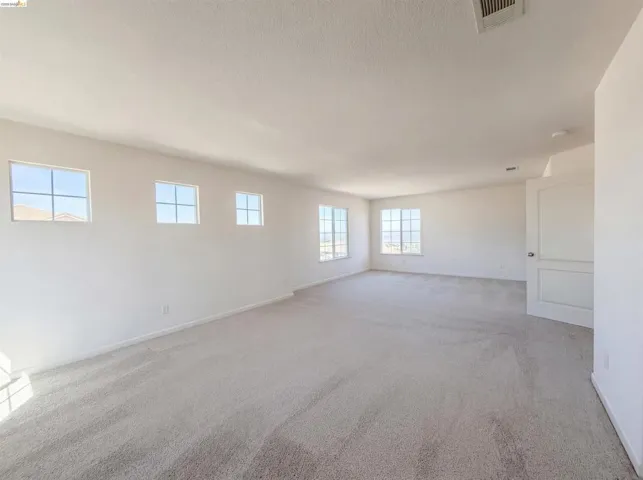 Spare room featuring carpet floors and baseboards