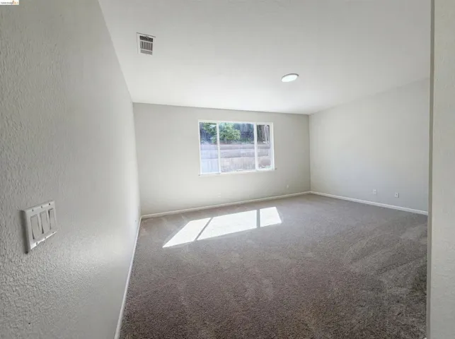 Empty room with carpet and a textured wall
