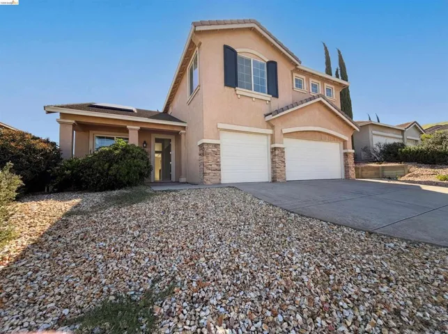 View of front of house featuring stucco siding, concrete driveway, a garage, and stone siding