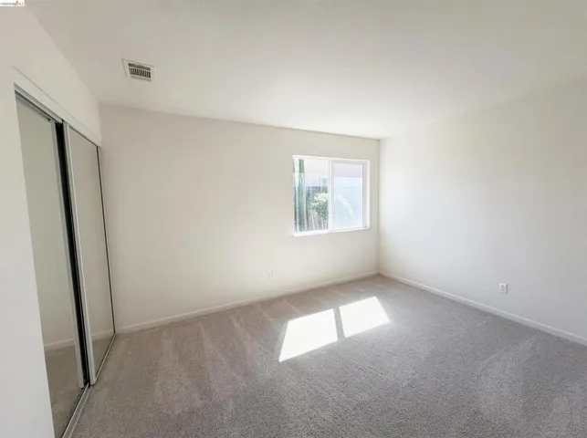 Unfurnished bedroom featuring a closet and light carpet