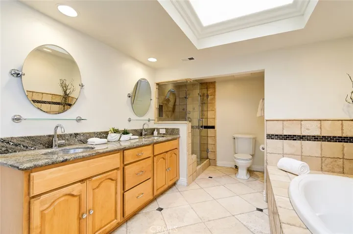 huge primary bathroom with skylight & dual vanities