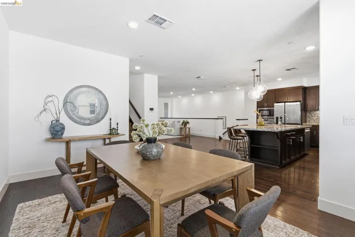 Dining space with dark wood-type flooring and recessed lighting