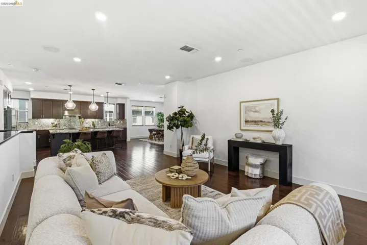 Living area featuring dark wood-type flooring and recessed lighting