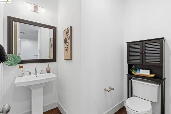 Half bath with toilet and dark wood-style floors