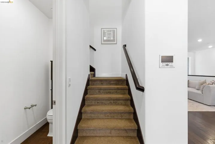 Stairs with hardwood / wood-style floors and recessed lighting