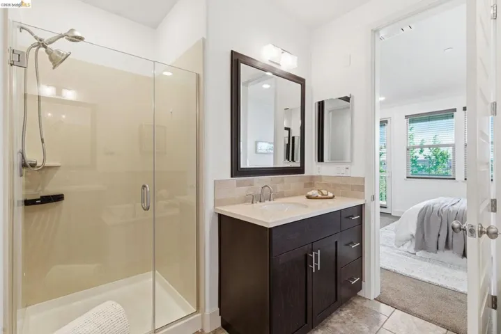 Full bathroom with ensuite bath, vanity, a stall shower, decorative backsplash, and light tile patterned flooring