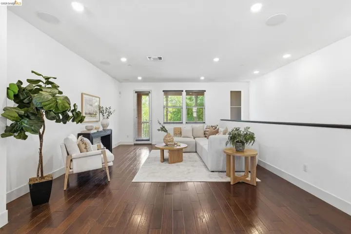 Living room featuring dark wood-type flooring, a fireplace, and recessed lighting