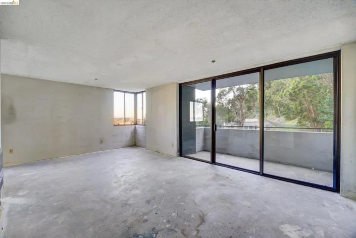 Empty room featuring a textured ceiling and concrete floors