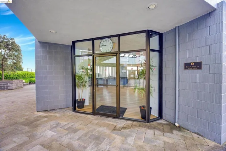 Entrance to property featuring a patio and concrete block siding