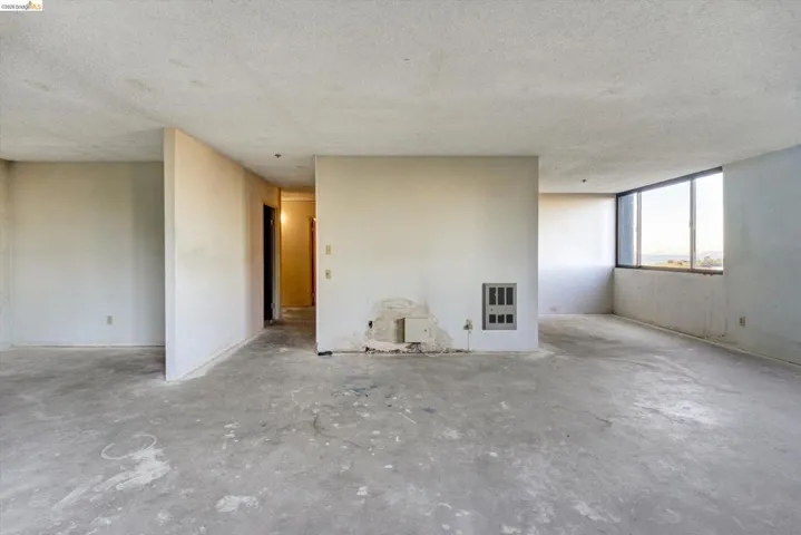 Unfurnished room featuring concrete flooring, a textured ceiling, and heating unit