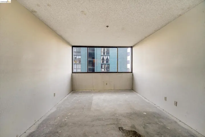 Spare room with a textured ceiling and unfinished concrete floors