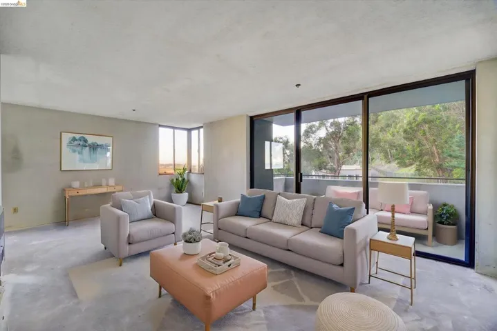 Living area featuring unfinished concrete floors, a textured ceiling, and floor to ceiling windows