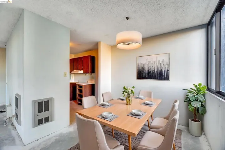 Dining room featuring heating unit, concrete flooring, and a textured ceiling