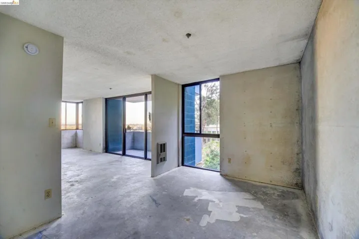Unfurnished room with concrete floors, a textured ceiling, and heating unit