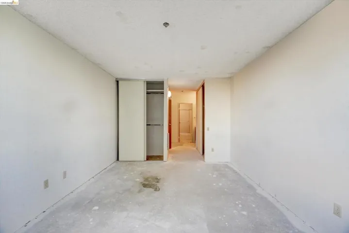 Unfurnished bedroom with concrete flooring, a closet, and a textured ceiling