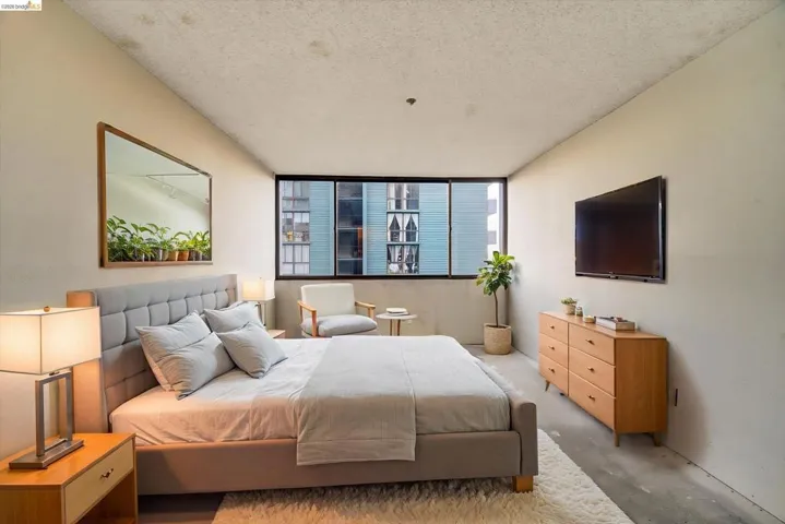 Bedroom featuring concrete flooring and a textured ceiling