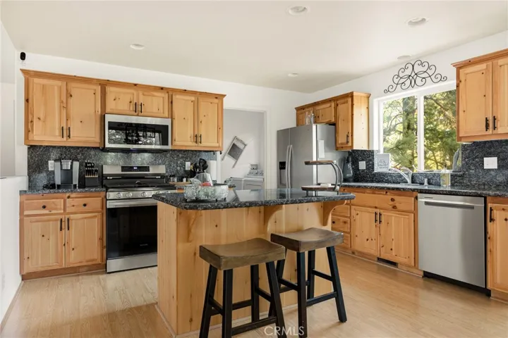 Kitchen with granite counter tops, & stainless steel appliances.
