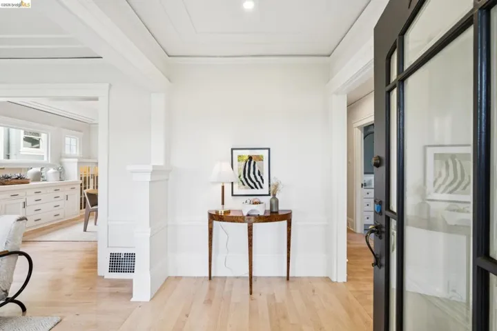Corridor with crown molding and light wood finished floors