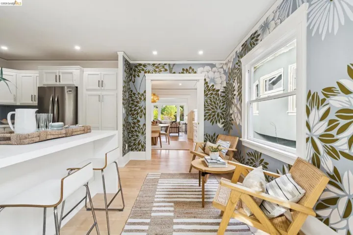 Living area featuring light wood-style floors, wallpapered walls, ornamental molding, and recessed lighting