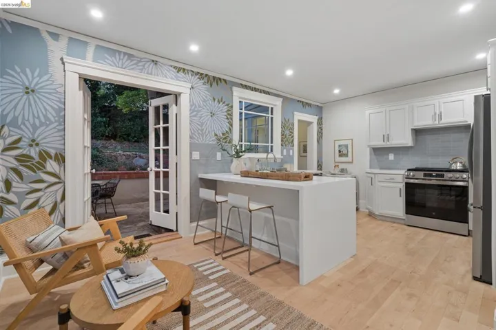 Kitchen featuring a peninsula, a breakfast bar, stainless steel appliances, white cabinets, and recessed lighting