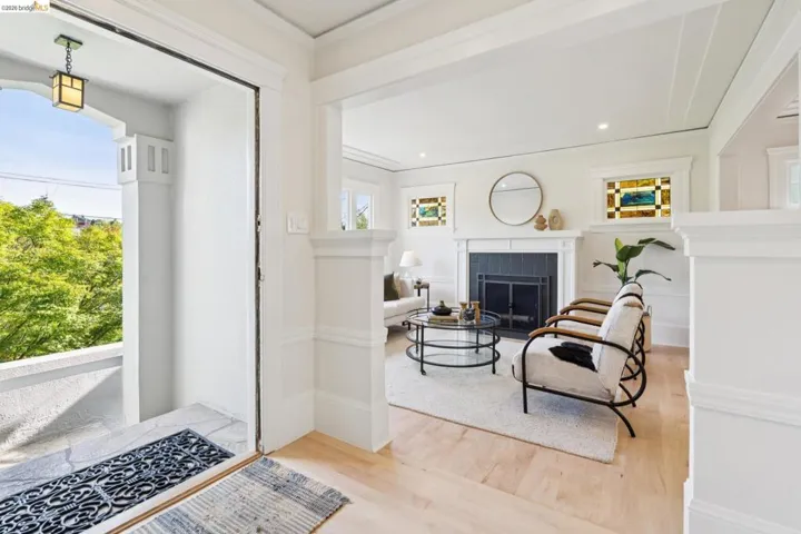Foyer featuring light wood finished floors, a fireplace, ornamental molding, and recessed lighting