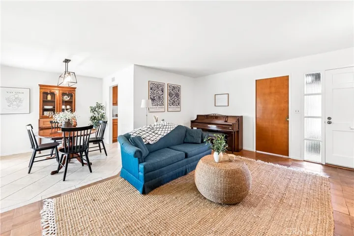 Bright living room with brick fireplace flows seamlessly to dining and covered outdoor entertaining area.