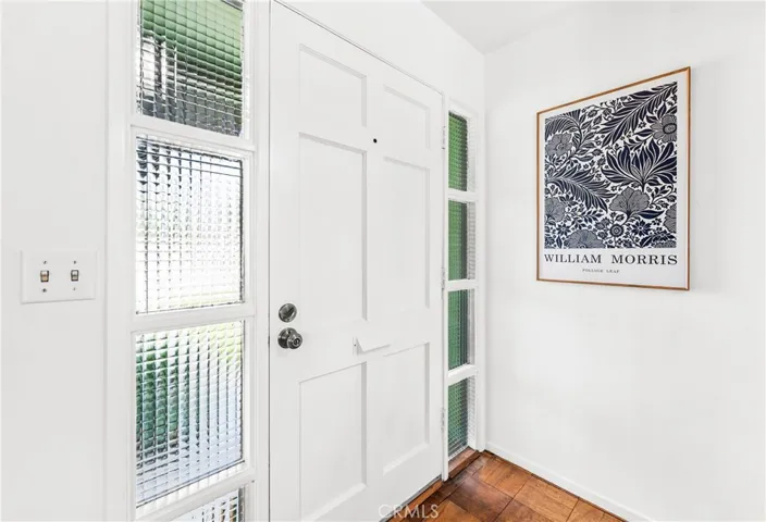 Bright white walls, abundant windows, and real wood floors create a cheerful interior.