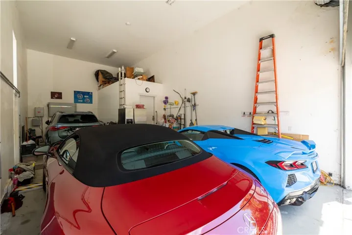 Versatile 3 car garage with 16.5' ceiling with roll up door. Could be used for RV, boat, cars, golf cart or add a car lift to increase the amount of cars that will fit in this garage.