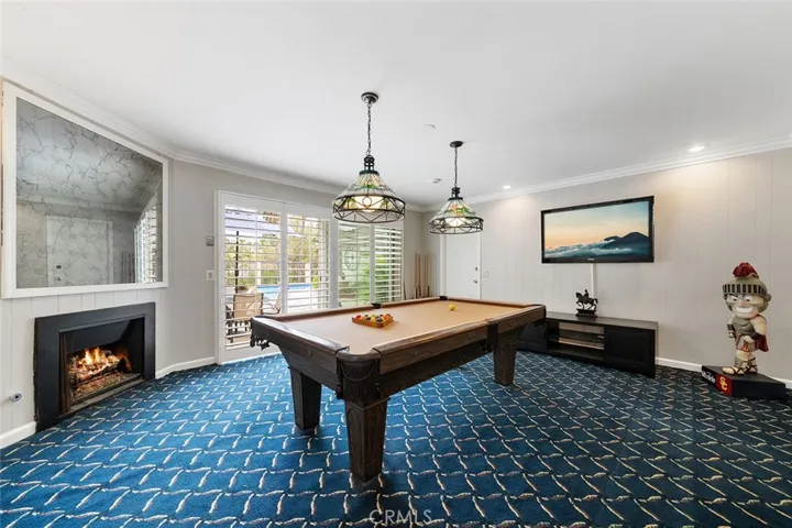 Bonus room with pool table, Tiffany style light fixtures, newly painted, sliders to the backyard. Fire in fireplace is photoshopped.