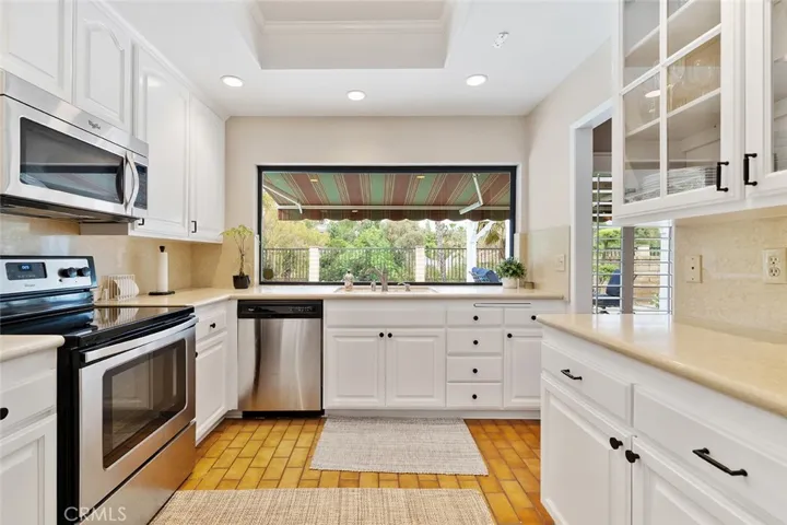Charming kitchen with large picture window overlooking the backyard.