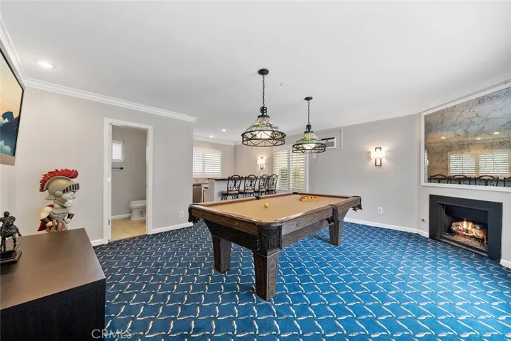 Great place to play and entertain. Pool table with Tiffany styled light fixtures. Newly painted and new light fixture along with recessed lighting. 3/4 bath and wet bar in the distance. Fire in fireplace is photoshopped.