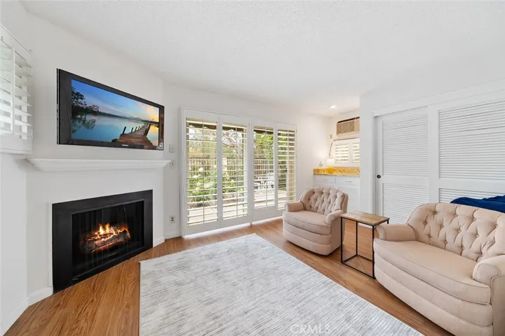 Extended room from the primary bedroom with fireplace. Fire is photoshopped. More storage space. This is a nice retreat area that could also be used as an office or workout setting. Sliders to the backyard.