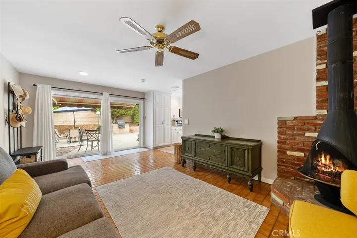 Cozy family room with sliders to the backyard. Woodburning stovepipe adds to the ambiance.Fire is photoshopped.