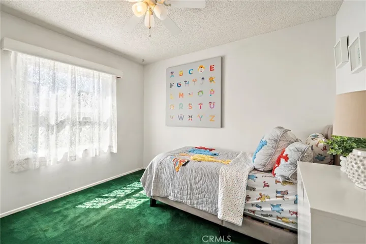 The bathroom features tile flooring and tiled walls, a tub/shower combination with dual shower heads and grab bars, and all three bedrooms are equipped with ceiling fans.