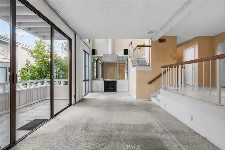 Living area with fireplace, large sliding glass doors, and access to a private balcony.