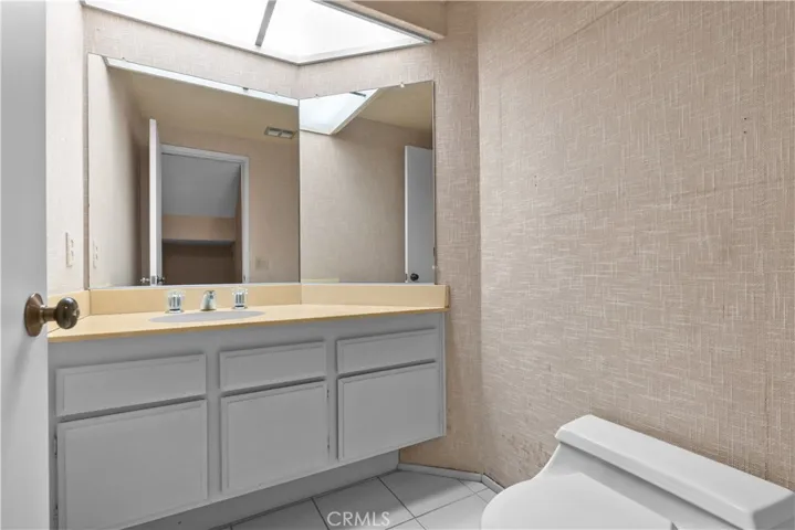 Ground-level restroom with vanity and storage cabinetry.