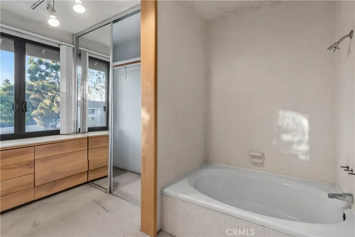 Primary bathroom features a tub and shower combination. Original balcony has been enclosed, adding additional interior space.
