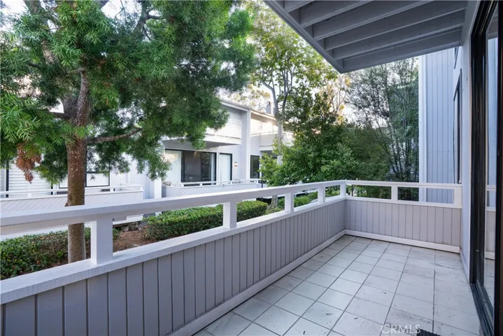 Private balcony with tile flooring overlooking landscaped ground