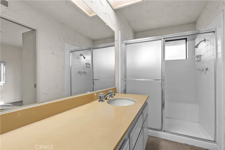 En-suite bathroom with vanity and walk-in shower.
