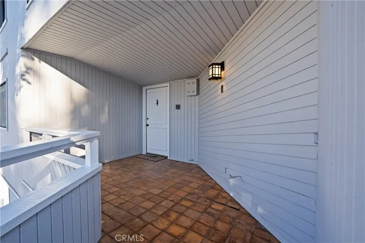 Covered entry terrace with tile flooring leading to the front door.
