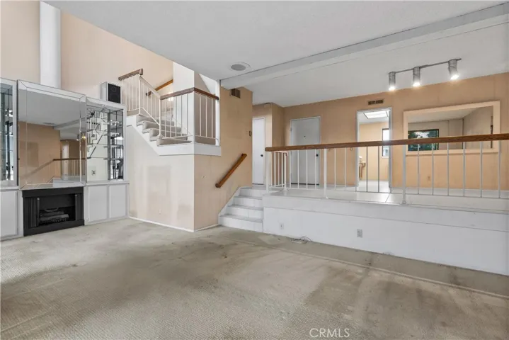 Living area with fireplace, large sliding glass doors, and access to a private​​‌​​​​‌​​‌‌​​‌​​​‌‌​​​‌​​‌‌​​‌‌​​‌‌​​​​ balcony.