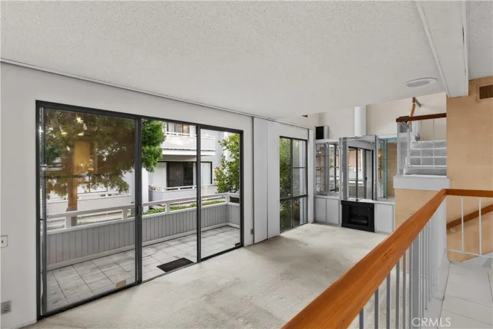 Open living area with fireplace, expansive sliding glass doors, and direct access to a private balcony.