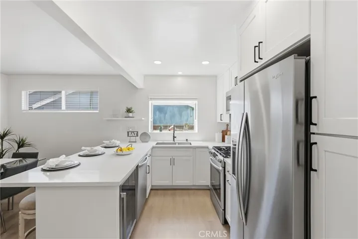 The kitchen is equipped with newer stainless steel appliances and a convenient beverage fridge.