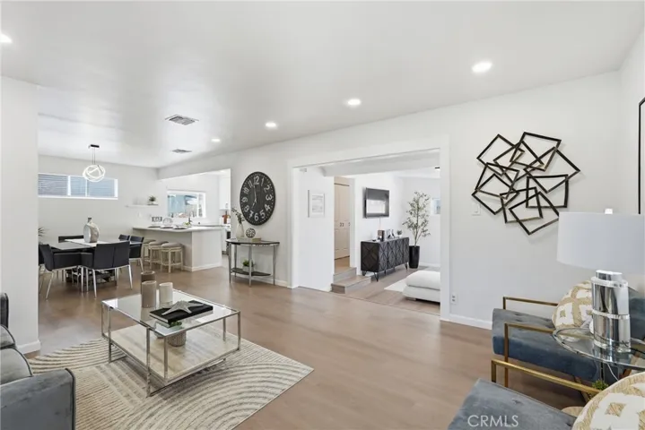 View from the front door showcasing the open-concept layout, where the living room, dining area, kitchen, and den flow seamlessly together.
